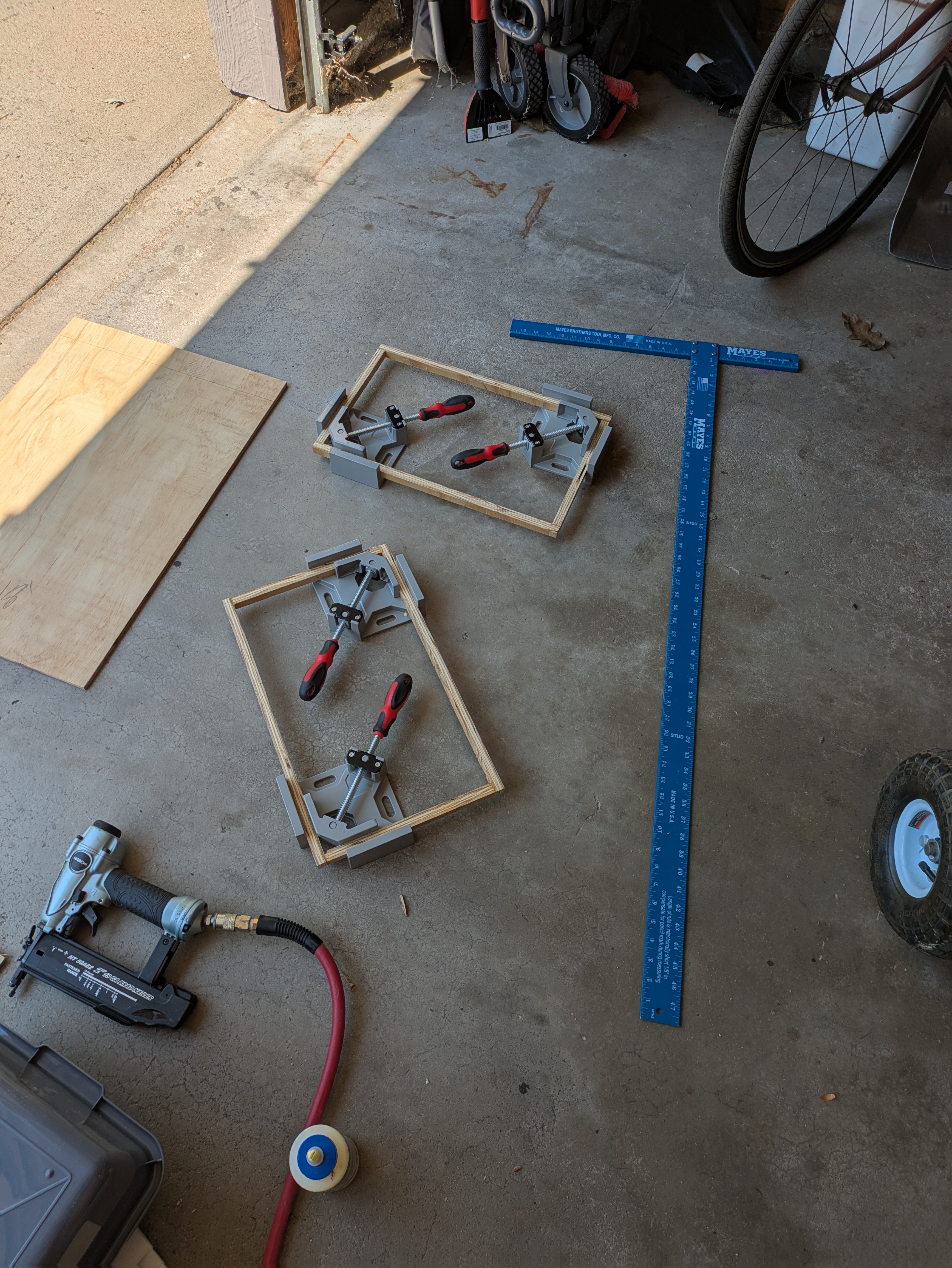 Two rectangles created with strips of plywood held together with angle clamps.