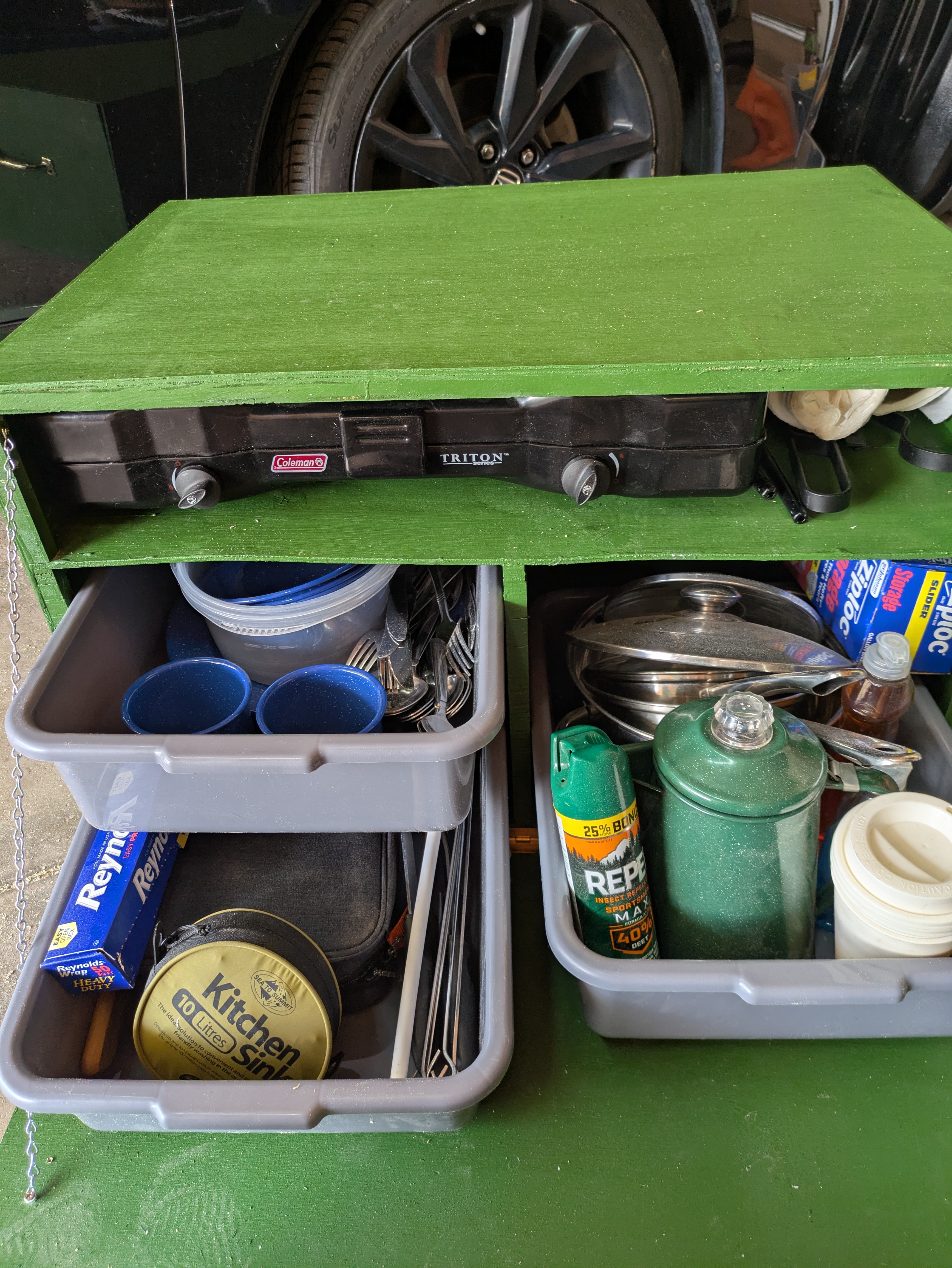 A green chuck box with the storage drawers pulled out showing the contents of the box.